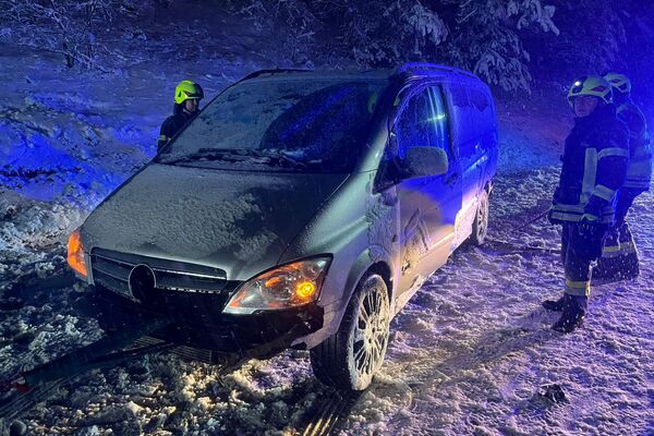Feuerwehrleute helfen einem verschneiten Van, der im Winter stecken geblieben ist, bei der Bergung. | © Name